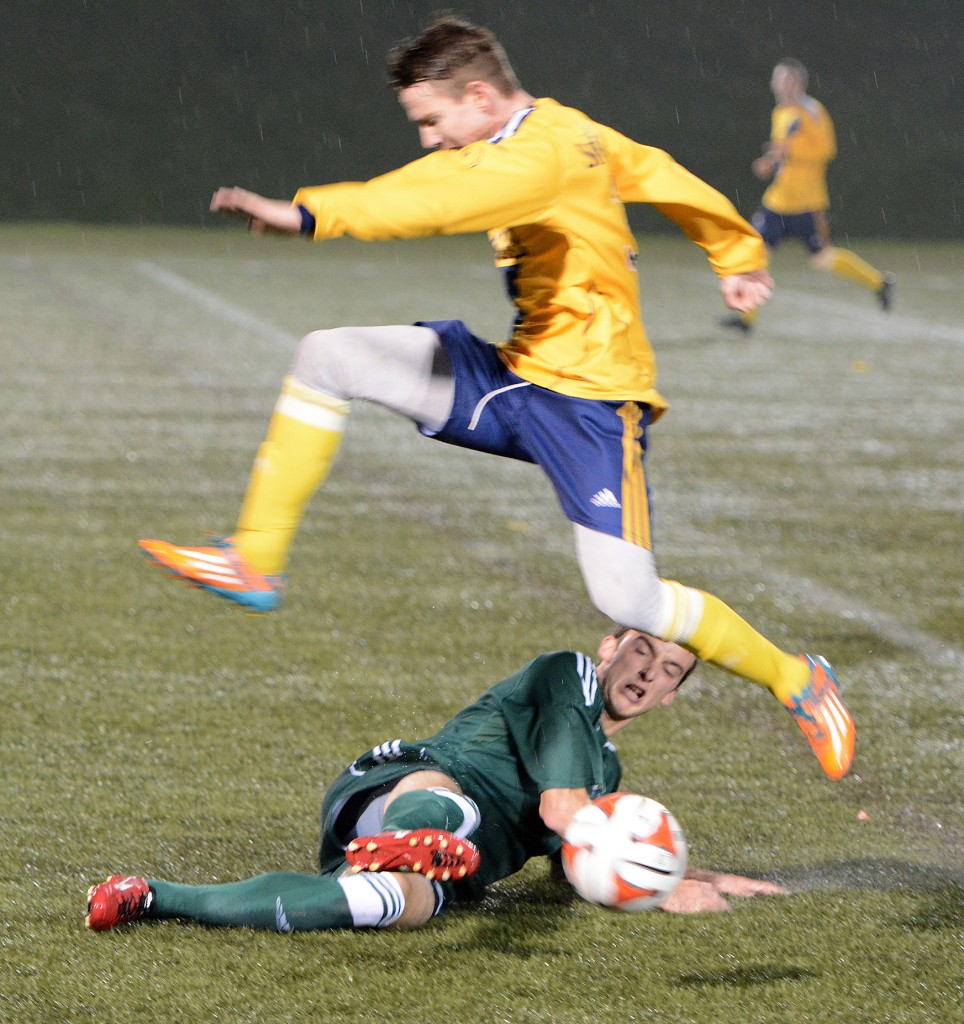 Daniel Davidson of the Cascades slides to knock the ball away from a TWU Spartans opponent.