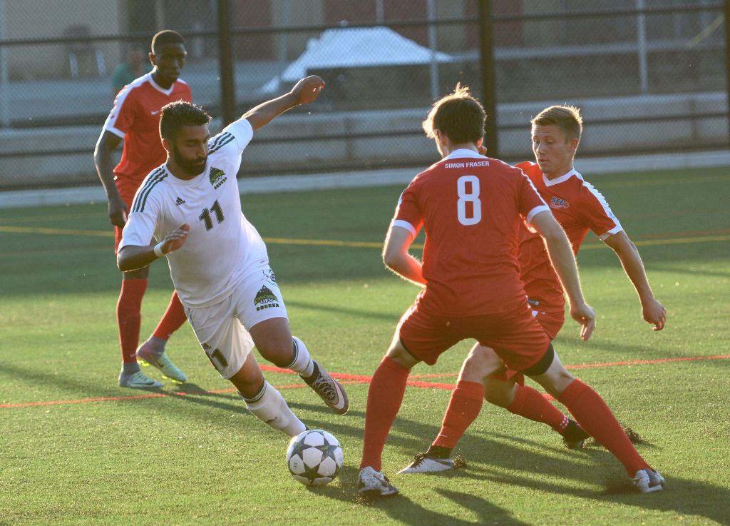 Cascades veteran Justin Sekhon attempts to elude a pair of SFU defenders during Thursday's exhibition match in Abbotsford.