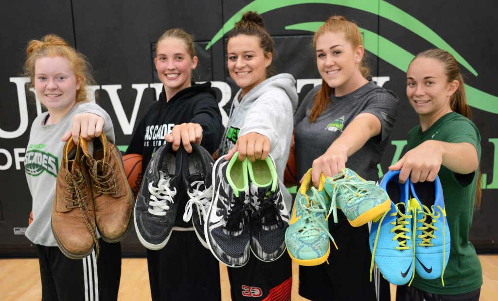 Katherine Holden, Jessica Cameron, Amanda Thompson, Taylor Claggett and Amelia Worrell of the Cascades hold up some of the shoes they've collected for Soles4Souls.