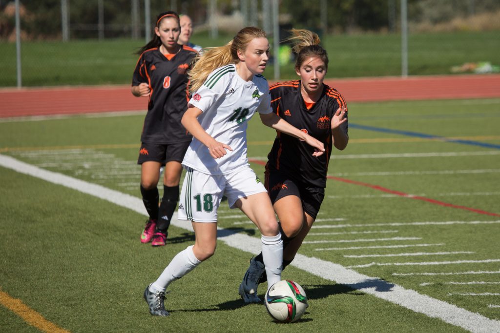 UFV's Amanda Carruthers pushes the ball up the pitch with a TRU defender in pursuit.