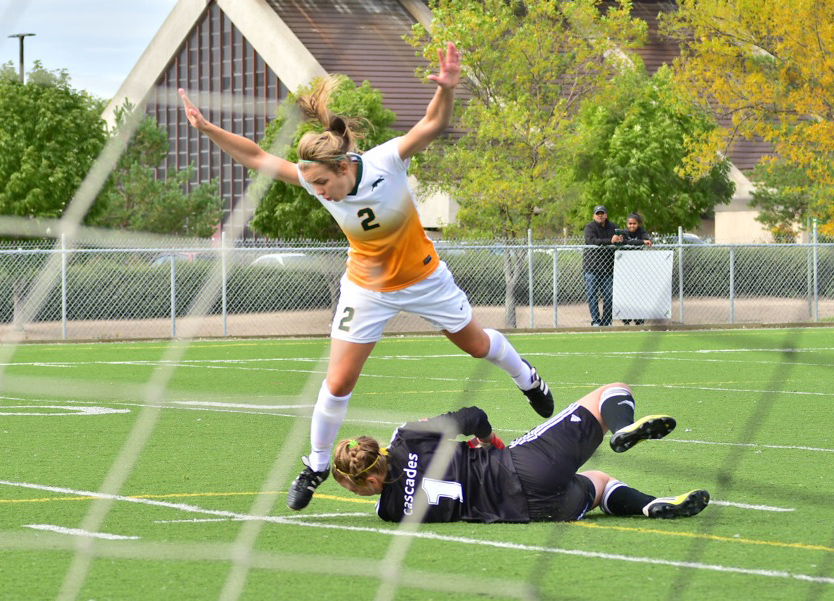 Kirsten Finley of the Regina Cougars leaps over Cascades keeper Kayla Klim during Saturday's game in Regina. (Photos courtesy Regina Cougars Athletics)