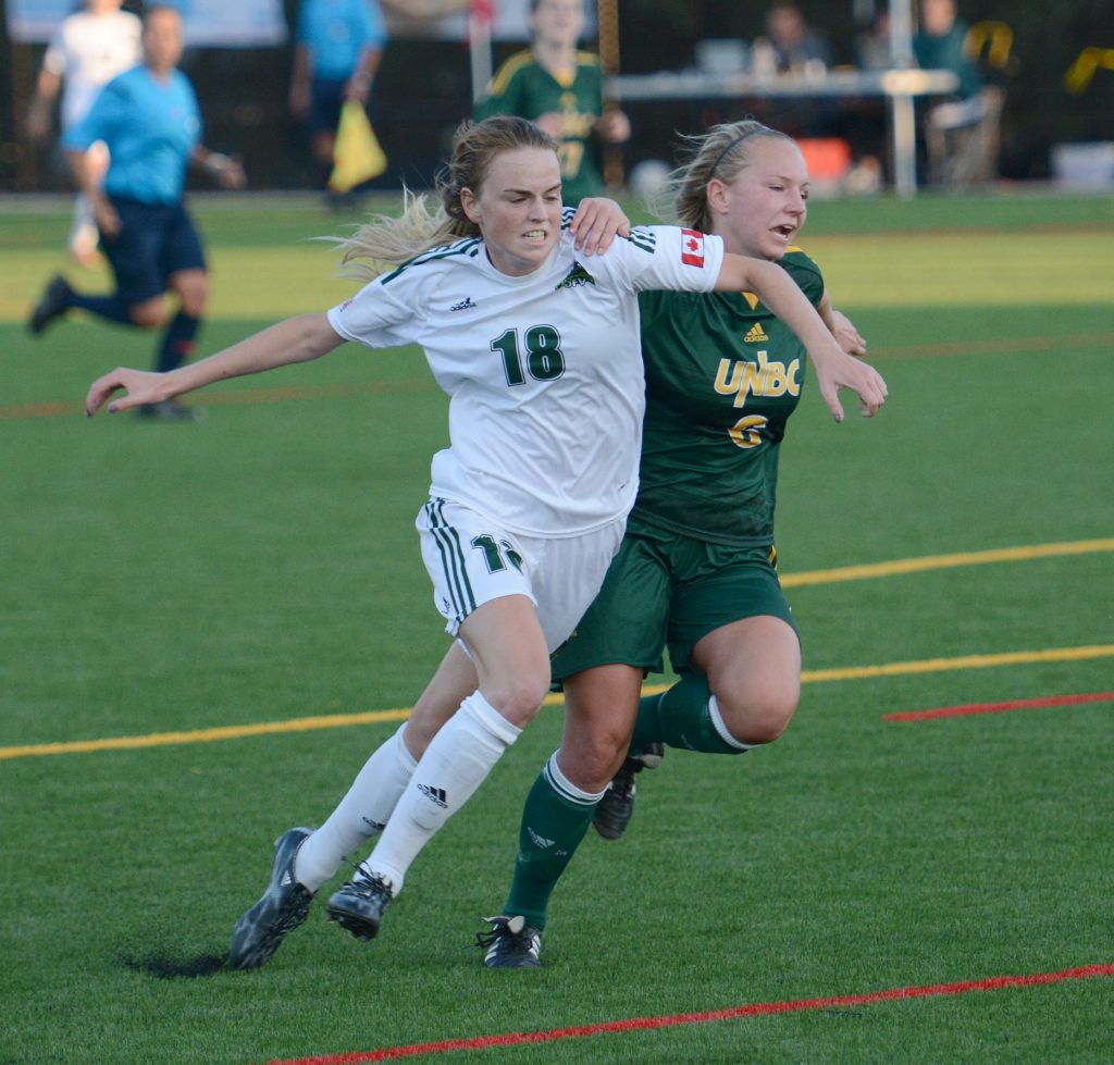 Amanda Carruthers (left) battles for position with a UNBC defender.